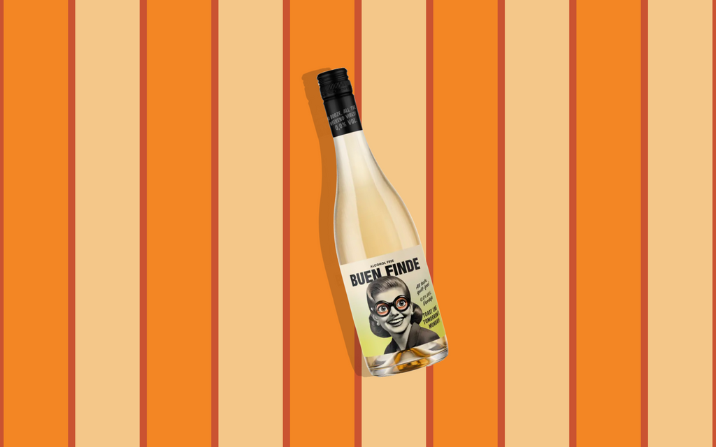 Botella de vino blanco sin alcohol Buen Finde sobre un fondo de rayas verticales en tonos naranja y crema