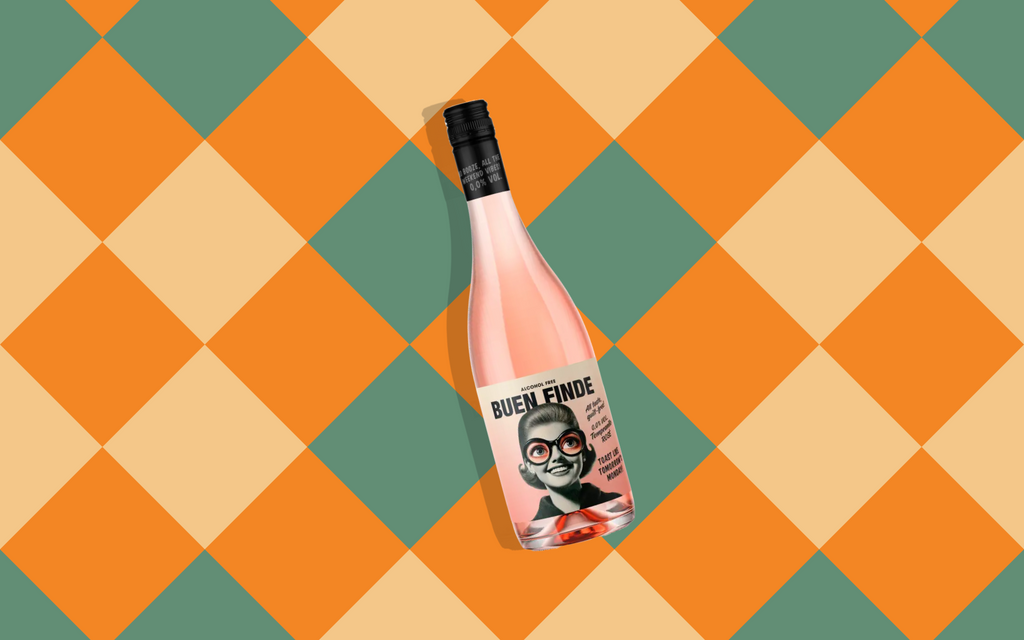 Botella de vino rosado sin alcohol Buen Finde sobre un fondo de patrón geométrico a cuadros en tonos naranja y verde