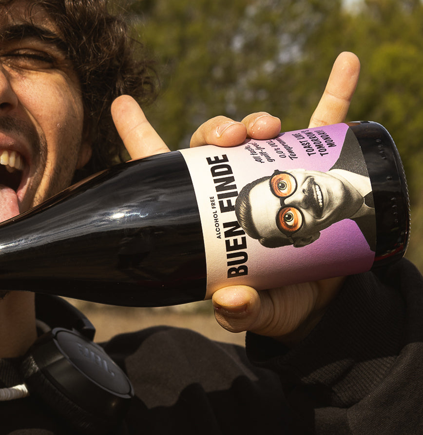 Joven celebrando con una botella de vino tinto sin alcohol Buen Finde Tempranillo